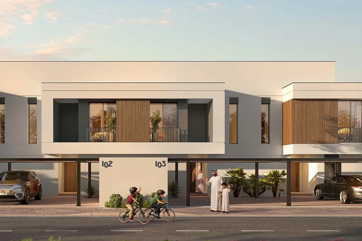 Children with bicycles outside a 3-bedroom Al Ghadeer Gardens townhouse